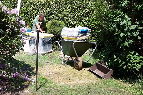 Medewerker voert groenafval af in big bags tijdens een tuinrenovatie