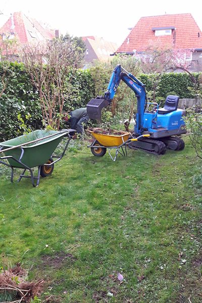 Minigraver en kruiwagens tijdens de renovatie van een achtertuin
